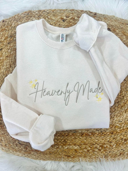 White sweatshirt with 'Heavenly Made' text on a woven surface